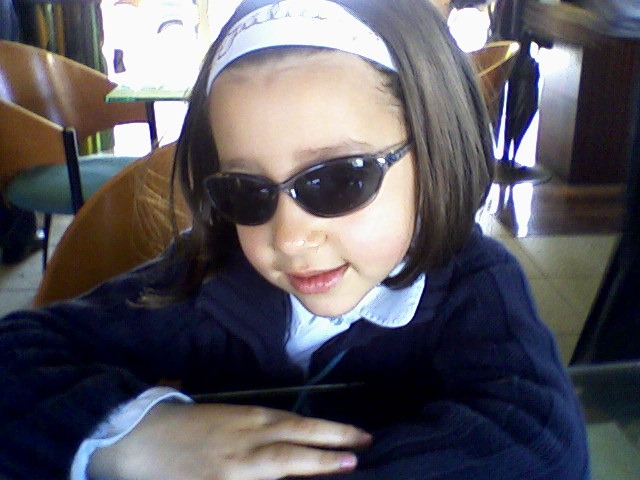 Júlia as a child wearing sunglasses